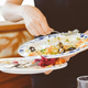 Busser clearing dirty plates at restaurant